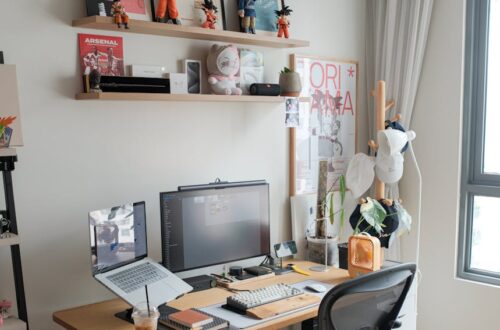 Contemporary home office setup with desk, computer, and creative shelves displaying figurines and art.